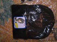 Entire beanie in plastic showing cuff and patch