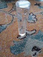 rod standing vertically showing cylindrical form and bubble inclusions