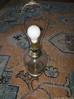 full view of table lamp with bulb and harp