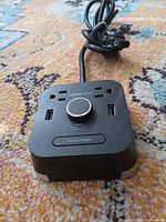 Top view showing outlets, USB ports and attached power cord