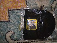 Front view of black beanie with Majin Vegeta patch in plastic wrap