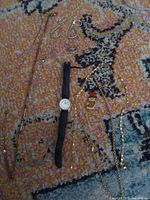 Entire lot laid out showing necklaces, earrings, watch, pendant