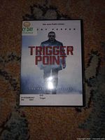 Front cover of Trigger Point DVD case showing title, actor name, library sticker