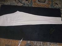 Full view of white leggings laid flat