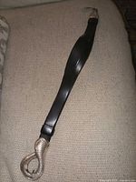 Full view of black leather belt showing cobra head loop and entire length