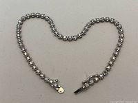 Full view of diamond bracelet laid flat showing overall design and missing stone