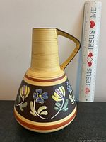 Front view of vase beside ruler showing height