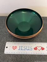 Top view showing green enamel interior and copper rim with ruler for scale