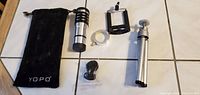 Full kit laid out: pouch, lens, phone clamp, ring adapter, accessory mount, mini tripod