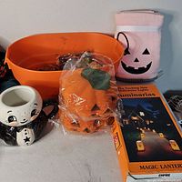 Group shot of entire lot showing luminarias box, cat mug, bowl, pumpkin light covers, fleece throw