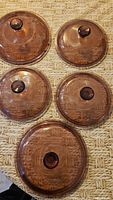 Five amber glass lids of varying sizes displayed top view