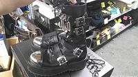 Side view of both boots showing buckles, platform soles, chrome toe caps