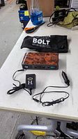 Jump starter, AC charger, car charger and pouch on table