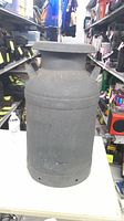 Full view of milk can front showing lid, handles, body