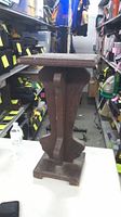 full view of wooden pedestal stand on table