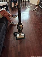Full view of vacuum standing on floor with charging dock attached
