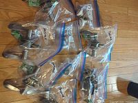 Multiple zip bags each containing a door handle or knob set with latch hardware