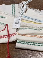 Stack of bibs showing various colored stripe designs and red finished bib on top