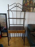 Front view of entire baker's rack showing metal frame, shelves, wood top and drawer