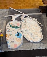 All pieces laid out: patterned mat, two arches, two crescent pillows, extra cover