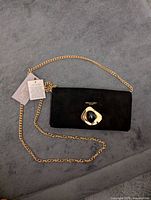 Full view of clutch with chain strap and tags attached