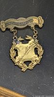 Front view of pin showing engraved McKeough top bar and Excellence medallion