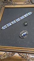Bracelet, ring and brooch grouped on display surface