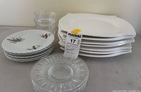 Stacks of seven white dinner plates, six bird motif dessert plates, six clear glass dessert plates, three clear glass bowls