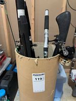 Cardboard tube holding multiple fishing rods and attached reel