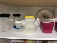 Shelf showing Luminarc jars, assorted plastic containers, ceramic pie dish