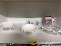 Assortment on shelf: shell dishes, Royal Albert bowls, mug, glass tealight holder