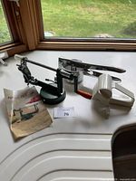 Lot overview showing apple peeler, potato ricer, rotary cheese grater and leaflet