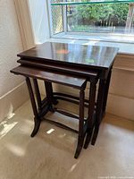Three nesting tables stacked, front-left view showing tops, legs and stretchers