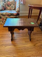 Front angled view of wooden bench showing top, apron and legs