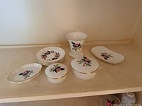 All nine Hathaway Rose pieces grouped on shelf
