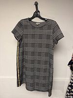 Front view of Twik houndstooth tunic top on hanger