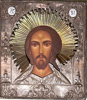 Full view of icon showing painted face, metal riza, and halo
