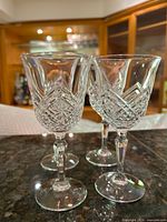 Front view of four cut-crystal wine glasses
