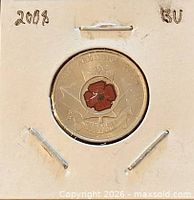 Coin in holder showing reverse coloured poppy design