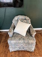 Front view of armchair with pillow showing fabric pattern and skirted base