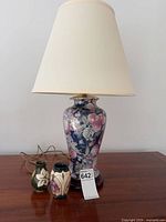 Lamp with shade and two vases on tabletop