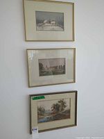 Three framed prints hanging vertically on wall
