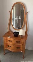 Full view of dresser with mirror, lamp, pot on top