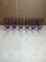 Twelve lilac stemware pieces lined up