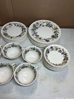 Stacked plates, cups and bowls showing grapevine rim pattern