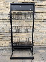 Full view of rack showing frame, three visible baskets, base with casters