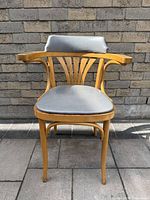 Front view of bentwood armchair showing curved frame, fan backrest, grey seat and back cushions