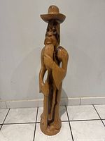 Front view of tall carved wooden man sculpture