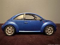 Left side profile of metallic blue 1/18 Volkswagen New Beetle