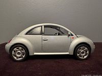 Left side profile of silver Volkswagen New Beetle model
